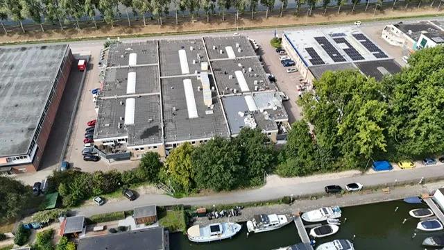 Luchtfoto van de platte daken van een bedrijfscomplex aan het water