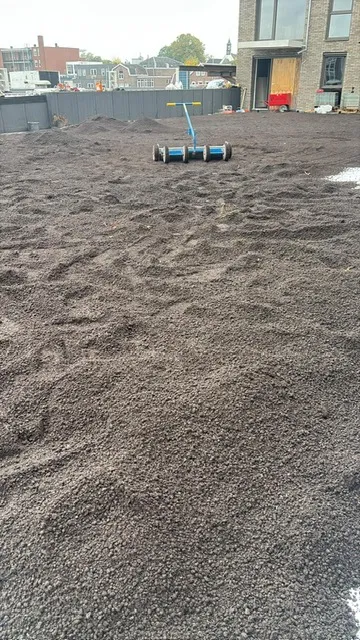 Substraat voor een groendak wordt geëgaliseerd met een roller